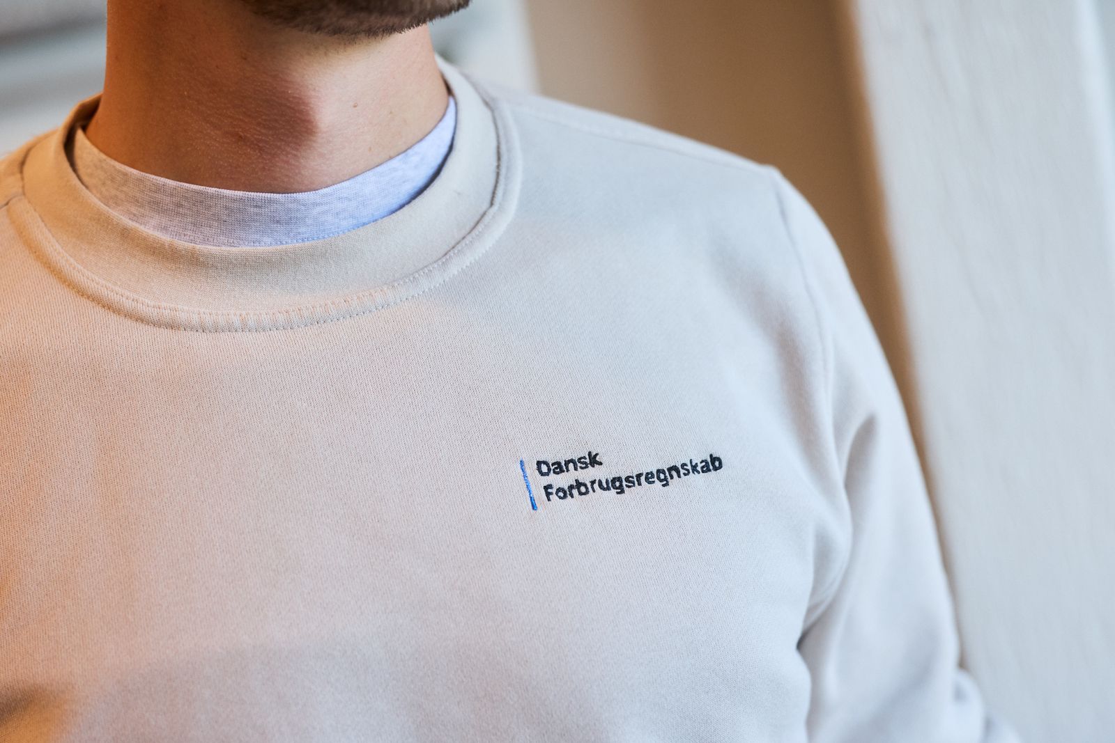 Dansk Forbrugsregnskabs logo broderet på en sweatshirt